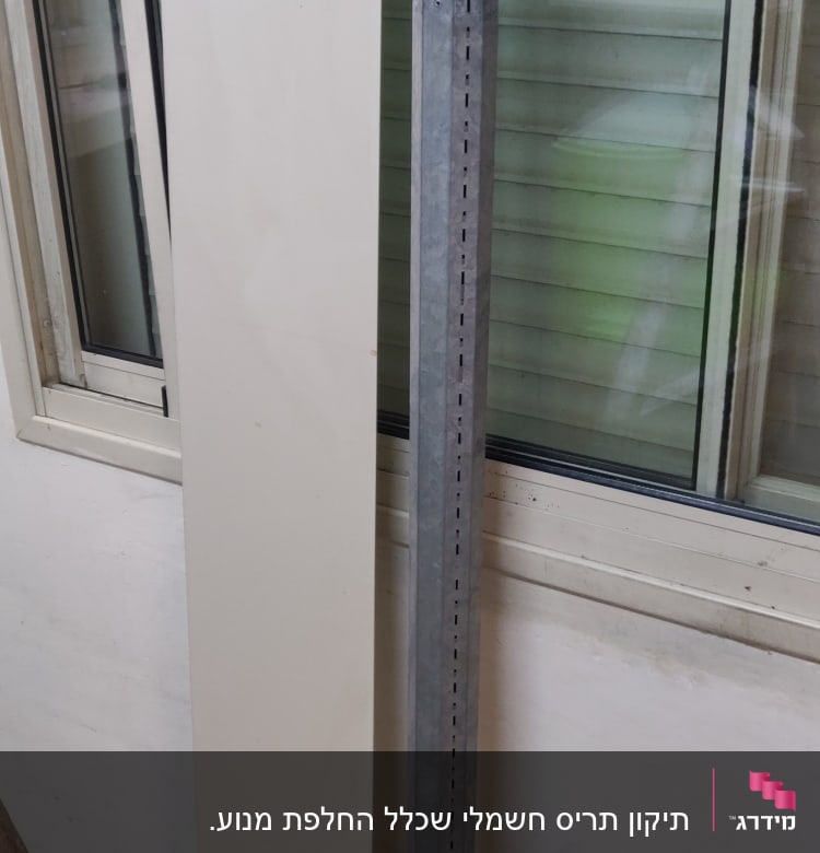 תריסים סגורים עם לוח מתכת ועמוד ליד חלון